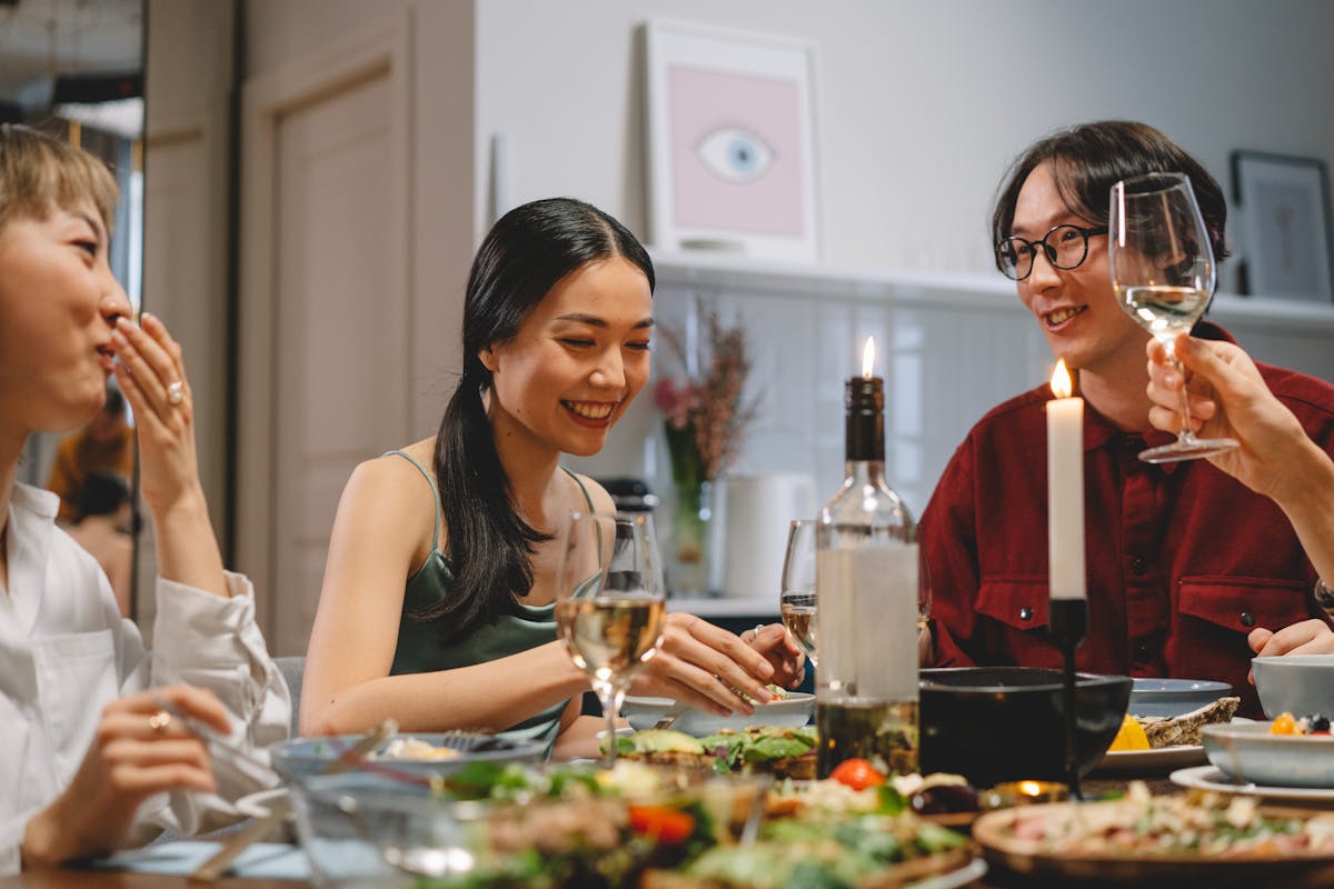 A dinner party table set with plates, glasses and candlelight, the setting for an infused cannabis dinner